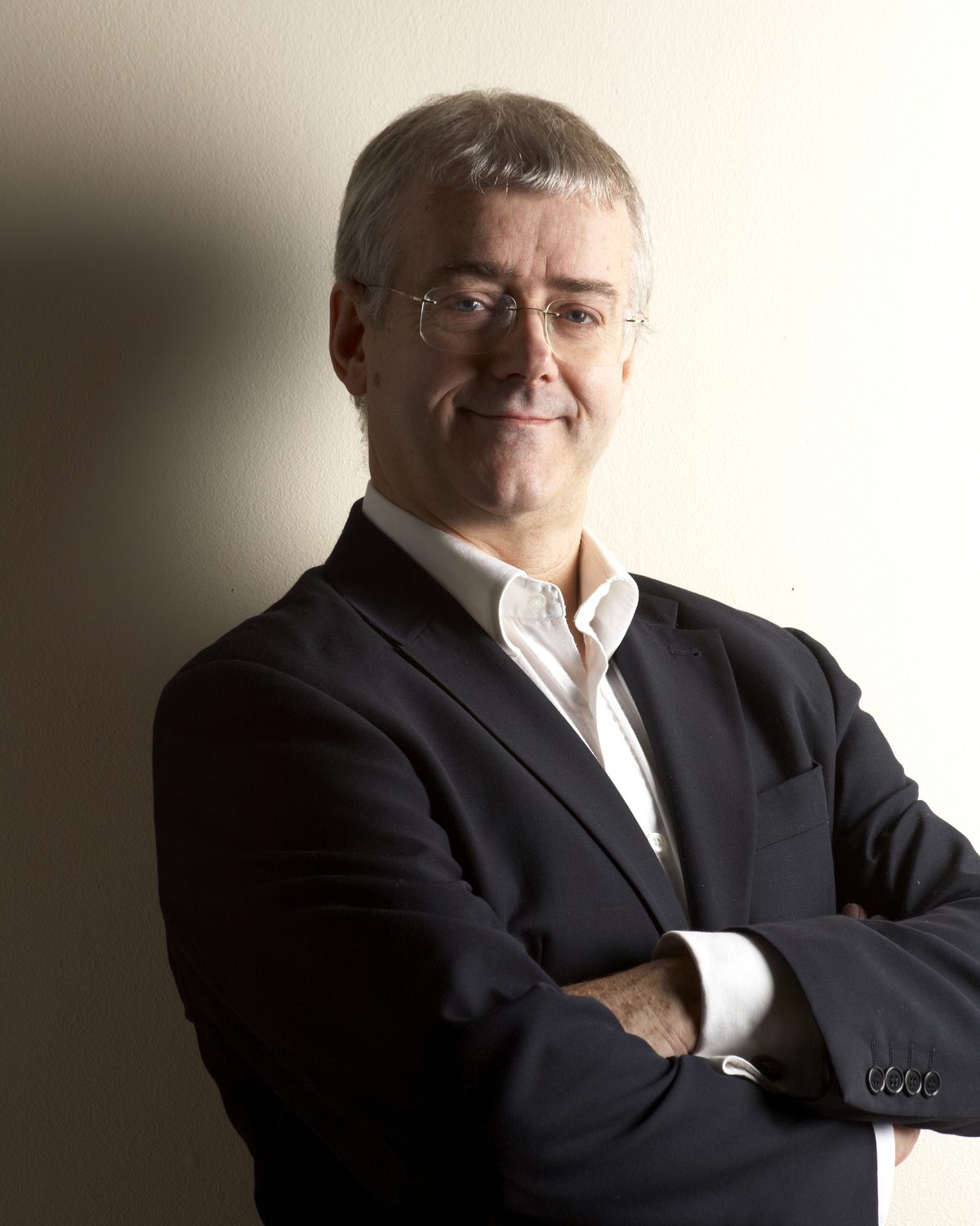 J E Symcox wearing a dark jacket and white shirt in a formal portrait.
